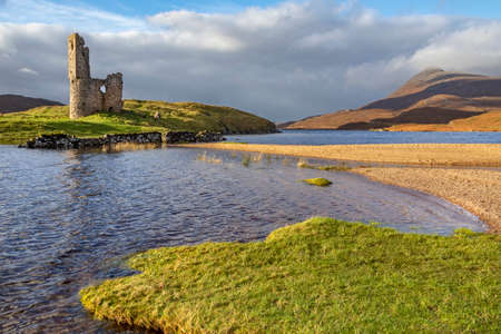 Ben Quineg and Ardvreck Castle - a ruined castle dating from the 16th century which stands on a rocky promontory in Loch Assynt in Sutherland, northwest Scotland. The castle was built in about 1590 by the MacLeods of Assynt.の写真素材
