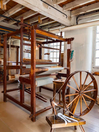 Industrial Heritage - Spinning Wheel and a simple hand-operated loom. A loom is a device used to weave cloth and tapestry. The basic purpose of any loom is to hold the warp threads under tension to facilitate the interweaving of the weft threads. The precのeditorial素材
