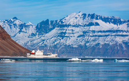 Tourist icebreaker exploring a fjord in Davy Sound on the northeast coast of Greenland.の写真素材