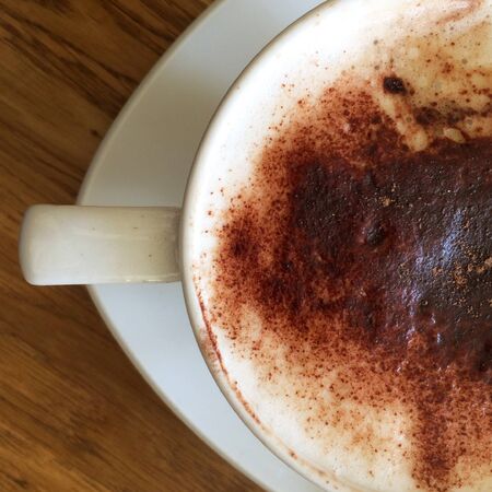 A cup and saucer containing cappuccino