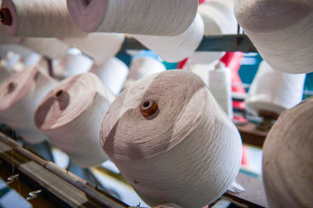 A row of bobbins on a cotton spinning machine