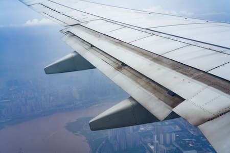 Airplane flap closeup and aerial city viewの写真素材