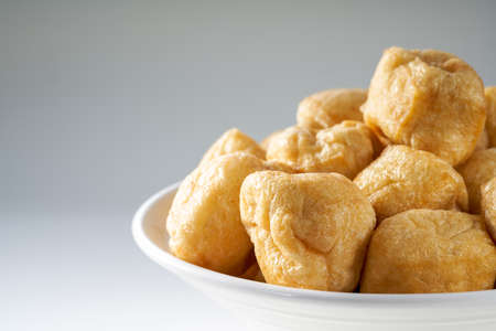 Close-up of a bowl of golden tempting fried tofu with avocado oilの写真素材