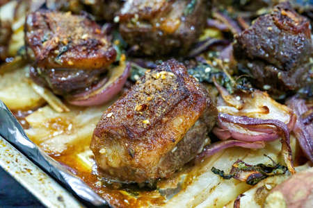 Closeup of a plate of grilled lamb chops with onions and potatoesの写真素材