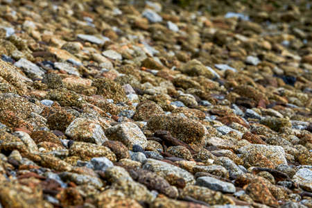 Crushed stones and huge rocks on the beach