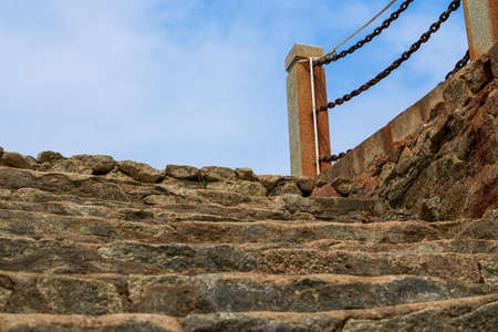 Abandoned pier stone stairs and rusty guardrails by the seaの写真素材