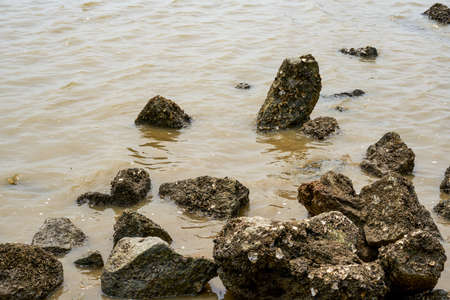 Crushed stones and huge rocks on the beachの写真素材