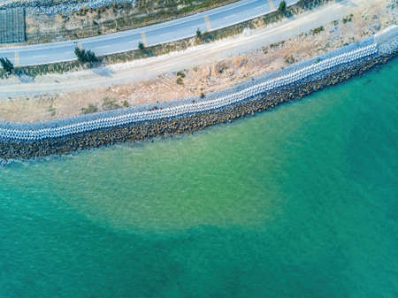 Cement block breakwater of coastal highway, aerial photography of highway seawallの写真素材