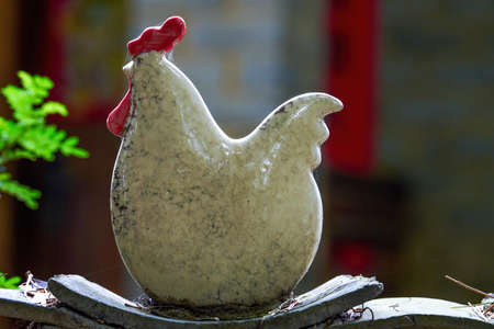 Close-up of a large ceramic rooster on a fence in rural Chinaの写真素材