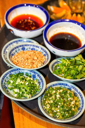 Various seasonings for hot pot, crushed peanuts, shallots, soy sauce, chili