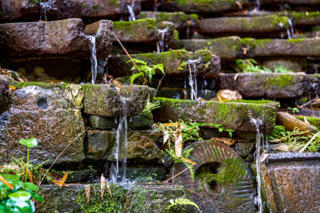 The flowing water sculpture landscape composed of many stone grinding discs in the park