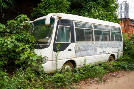 An old minibus passenger car parked in an abandoned industrial parkの写真素材