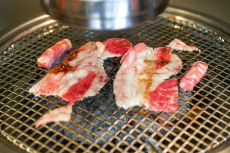 Grilled fat beef slices on Korean charcoal grillの写真素材