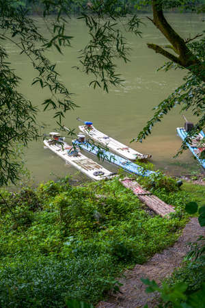 These wooden boats are docked by the river in the wild mountainsの写真素材