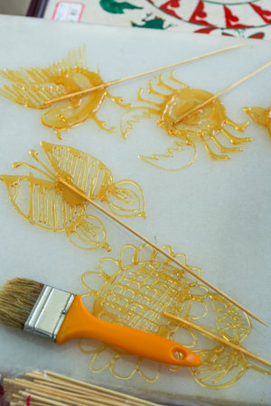 A craftsman is making traditional Chinese snacks, painting sugar paintingsのeditorial素材