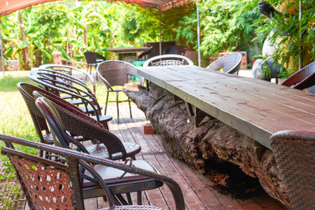 Closeup of large long wooden table in outdoor gardenの写真素材