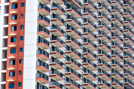 Close up of regular and neat balcony windows on a residential building in the cityの写真素材