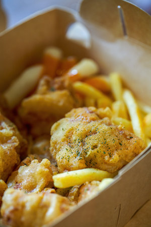 A delicious and crunchy Korean fried chicken served with fried rice cakesの写真素材