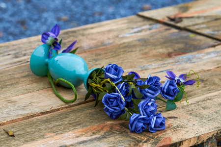 Vase of blue roses placed on wooden benchの写真素材
