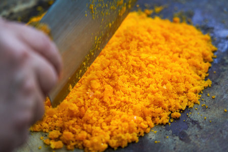 A chef is chopping salted egg yolk in the kitchenの写真素材