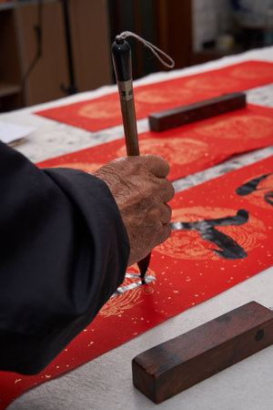 An old calligrapher writes couplets during the Chinese Year of the Dragon. Translation: Spring fills the world.の写真素材