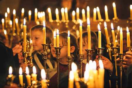 A group of adults and children light candles and pray in the churchの素材