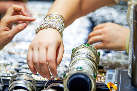 Close up of hands of female jeweler working in a jewelry shopの写真素材