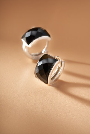 A pair of delicate earrings jewelry on an orange backgroundの写真素材