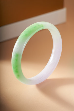 An elegant Chinese jade bracelet on an orange background
