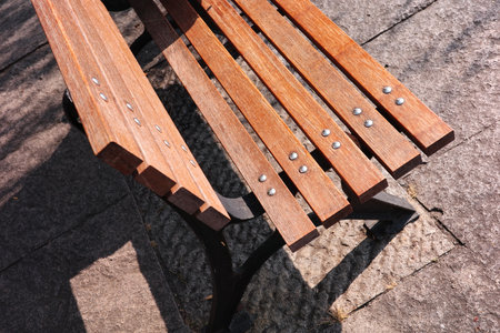 Close-up of a leisure wooden bench in a city parkの写真素材