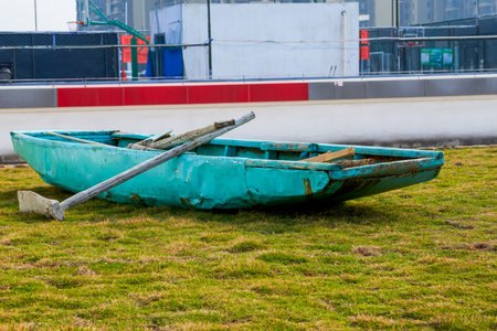 An abandoned wooden boat lying on the grass
