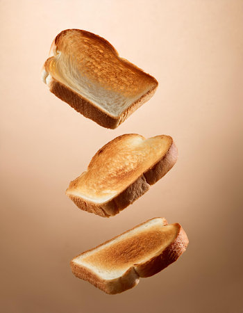 Flying toast bread isolated on brown background. Toast bread flying in the airの素材