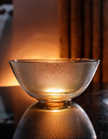 Candle light in a glass vase on a dark background.の素材