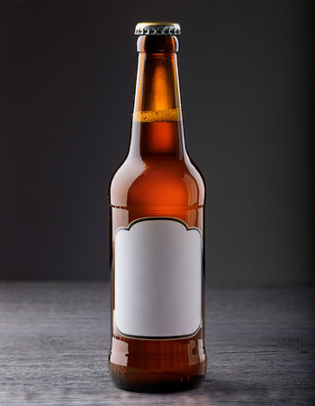 Bottle of beer with blank label on gray wooden table, studio shotの素材