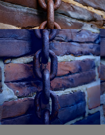 Rusty chain on the background of a brick wall. Selective focus.の素材