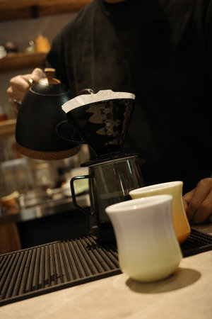 A barista is making hand-brewed coffee in a coffee shop