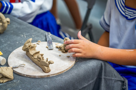 Several elementary school students sat together making pottery.の写真素材