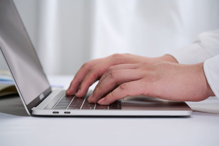 1 Business man typing on laptop keyboard in office