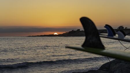 Classic Southern California surf scene with the sun going down and the longboards drying out at the beach after a long day of surfing.の写真素材