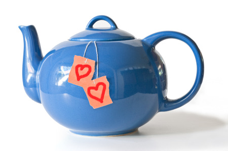 Blue tea pot containing teabags with heart symbols on isolated backgroundの写真素材