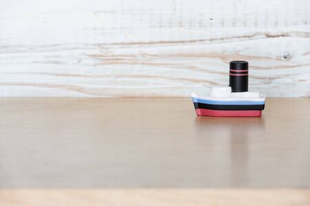 small, vintage, antique wood toy boat shot against neutral backgroundの写真素材