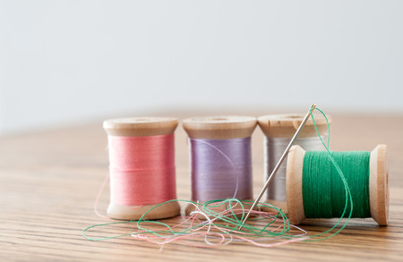 Multicolored spools of thread with threaded needle