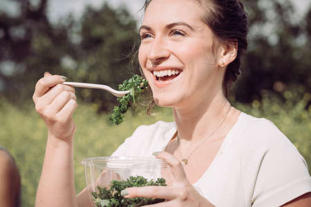 Young woman in white about to enjoy a healthy saladの写真素材