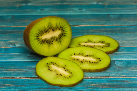 Juicy pieces of kiwi on a table, blue tableの写真素材
