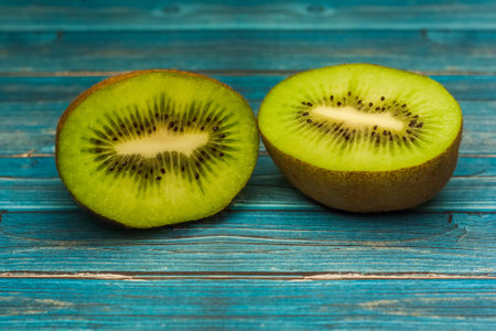 Two juicy kiwi halves on the table, blue tableの写真素材