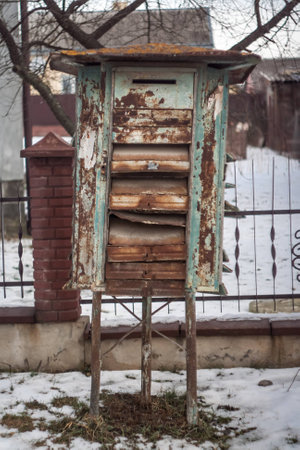 Old rusty mailbox, cloudy, bad weather on the street.の写真素材