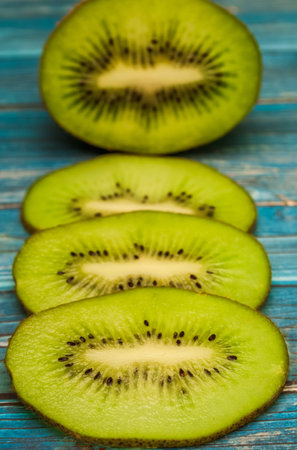 Juicy pieces of kiwi on a table, blue tableの写真素材
