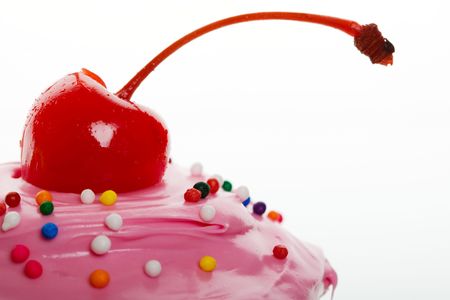 A macro shot of a cherry on top of a cupcakeの写真素材