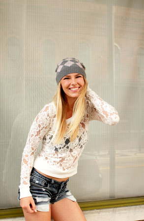 Smiling pretty young blonde woman candid portrait on city street の写真素材