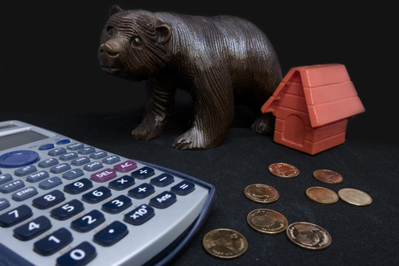 Money,calculator,coins bank with red house model on tableの写真素材